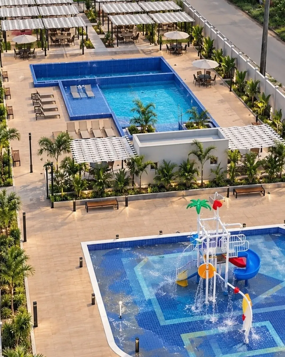 Perspectiva da área de lazer do condomínio, com piscinas e playground